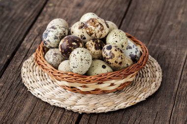 ahşap arka plan üzerinde bir hasır sepet içinde bıldırcın yumurtası