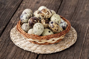 ahşap arka plan üzerinde bir hasır sepet içinde bıldırcın yumurtası