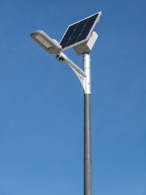 Bulutsuz mavi gökyüzünde güneş paneli ve lamba direği. İspanya