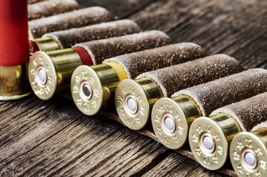 12 kalibrelik av tüfeği fişeklerine seçici yaklaşım. Deri bir kanananın içindeki ahşap bir masanın üzerinde.