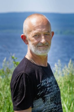 Gri sakallı, gülümseyen yaşlı bir adamın yakın plan profili.