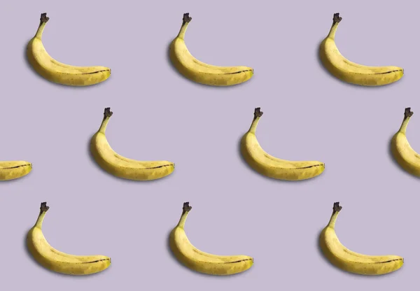 Mor arka planda izole edilmiş muz deseni. Yaz meyvesi.