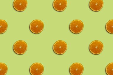 Yeşil arka planda yarım kesilmiş portakal deseni izole edilmiş. Taze. Doğa.