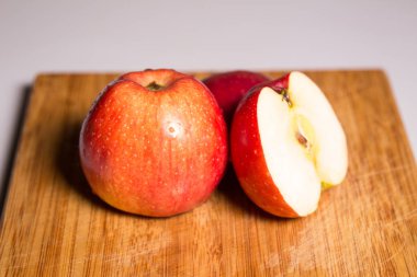 Tahta bir tahta üzerinde gölge ile üç kırmızı elma