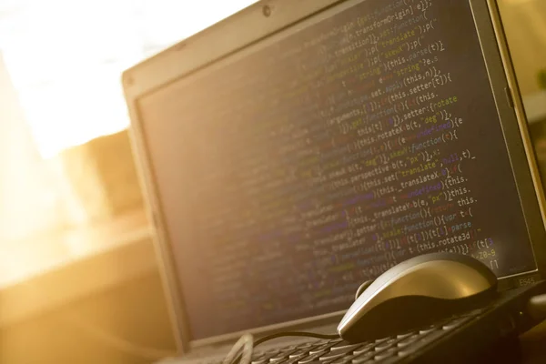 Web developer workplace. Laptop keyboard in the light of sun.