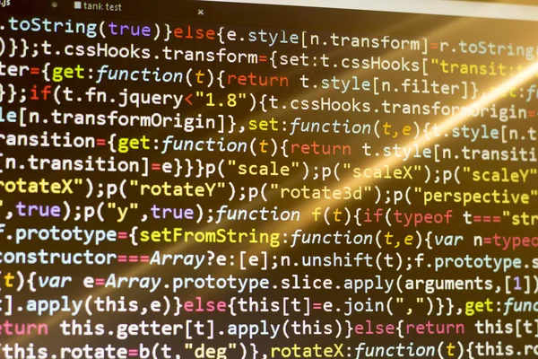 Minificated web development javascript code in sunset rays. Web developer workplace. Abstract information digital technology modern background.