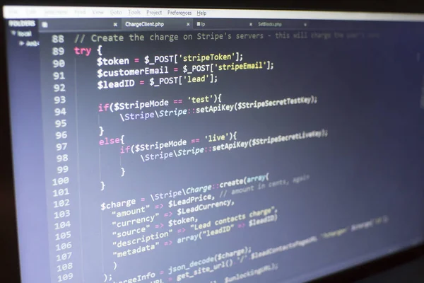 Web developer PHP code close up. Charging customer using Stripe API. Online payments processing. Abstract information technonology modern background. Concept screen of web developer.