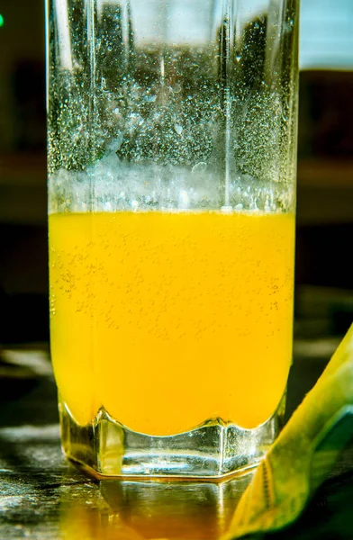 Glass of fizzy yellow vitamins drink near the medical blue mask. Illness prevention and health care concept