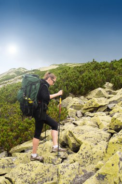 Dağlarda yürüyüş yapan genç bir kadın..