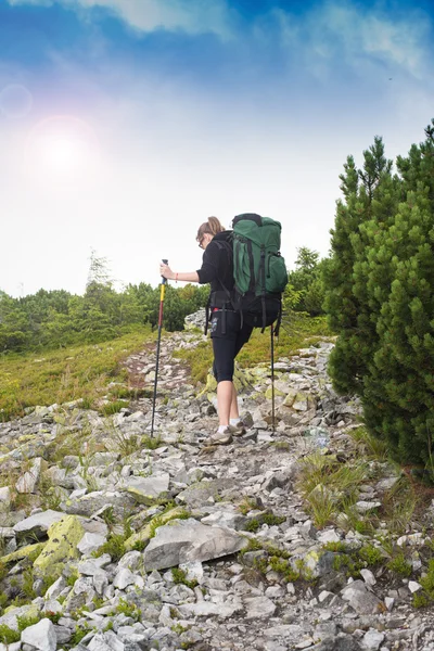 Dağlarda yürüyüş yapan genç bir kadın..
