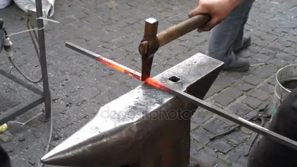 Ferreiro corta haste de metal aquecido — Vídeo de Stock