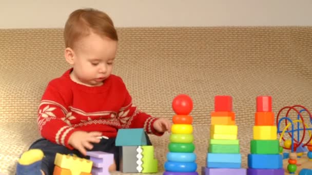 Niño jugando juguetes coloridos — Vídeo de stock