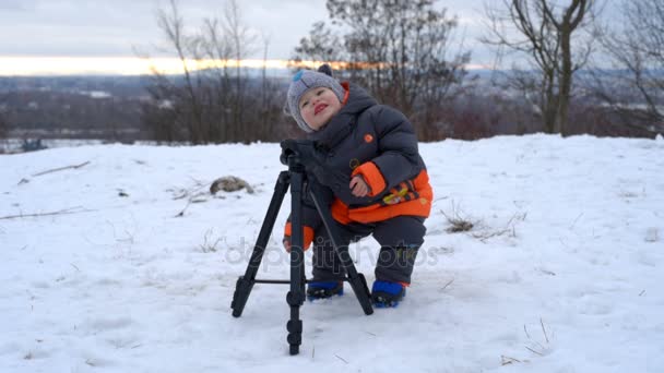 Cute kid playing with tripod — Stock Video
