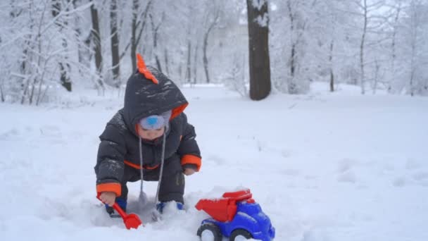 Niedliches Kind spielt mit Schnee — Stockvideo