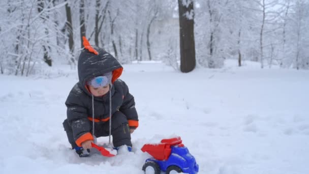 Niedliches Kind spielt mit Schnee — Stockvideo