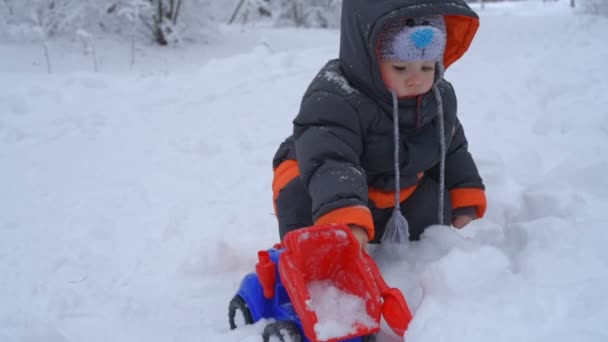 Kleine jongen spelen met sneeuw — Stockvideo