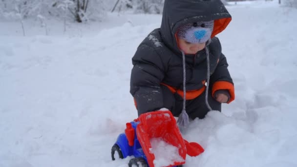 Malý chlapec hraje se sněhem — Stock video