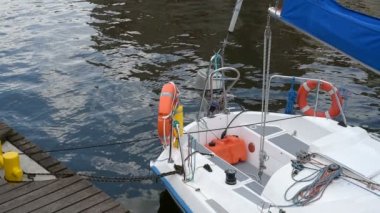 Demirli yat. Çevresinde dalgalar nedeniyle kırbaçlanan limandaki tekne palamarla. Güneşli bir günde okyanus üzerinde bir sonraki yolculuk için bekleyen rıhtımda döşeme yelkenli. dalgalar