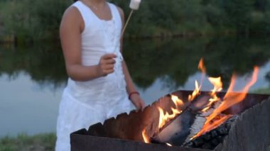 Marshmallow kamp yanıyor. kamp, seyahat, turizm, yürüyüş ve insanlar kavramı - hatmi kamp ateşi kavurma mutlu bir aile. hatmi şiş üzerinde. Stick şenlik üzerinde tatlı şekerleme