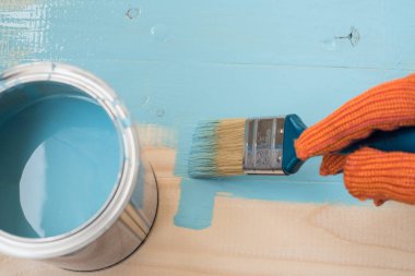 alt kurulu mavi boya boyar. Mavi boya ve fırça ahşap arka plan üzerinde. alt boya kurulu