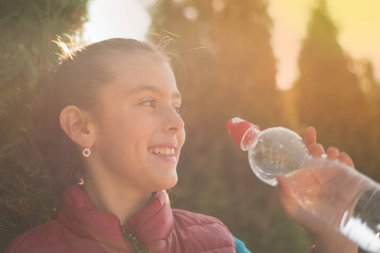 Güzel kız içme su içinde açık koşu yaptıktan sonra. İçme suyu sıcak güneşin parkta güzel bir kızdır. Sağlıklı kavramı. Sağlıklı yaşam konsepti. kopya alanı. Portre güzel kız