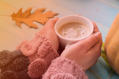 WOMANS süveterli kahve mavi ahşap masa üzerinde tutan eller. Tatil kavramı. Bir fincan kahve ahşap antika arka plan - kış zaman kavramı üzerinde tutan kız. Kahve fincanı