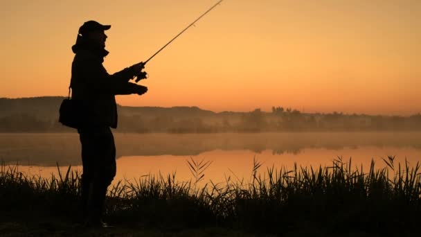 日の出漁師のシルエット 朝釣りの漁師 漁師の夕暮れのシルエット スポーツ趣味釣り 夜明けの朝釣り — ストック動画