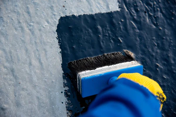 Worker applies bitumen mastic on the foundation — Stock Photo, Image