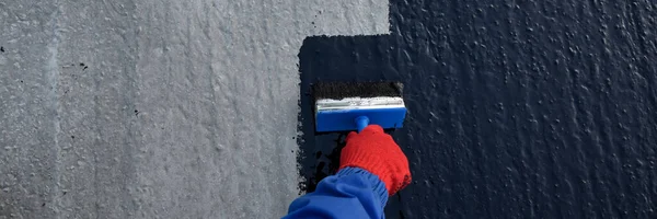İşçi temel üzerine bitumen mastic uygular