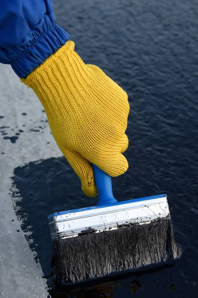 Worker applies bitumen mastic on the foundation — Stock Photo, Image