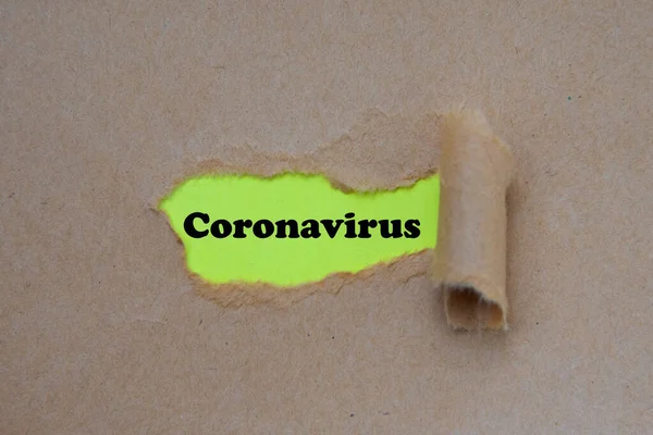 कोरोनावायरस शब्द टूटे हुए कागज के नीचे लिखा गया है। संकल्पना . — स्टॉक फ़ोटो, इमेज