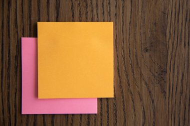 Ahşap arkaplan resmi üzerine renkli yapışkan notlar.