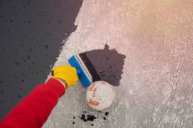 İşçi temel üzerine bitumen mastic uygular