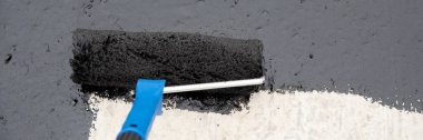 İşçi temel üzerine bitumen mastic uygular