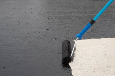 İşçi temel üzerine bitumen mastic uygular