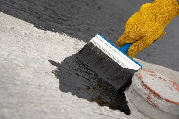 Werknemer brengt bitumen mastiek aan op de fundering — Stockfoto