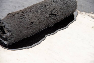 İşçi temel üzerine bitumen mastic uygular