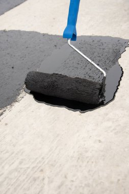 İşçi temel üzerine bitumen mastic uygular