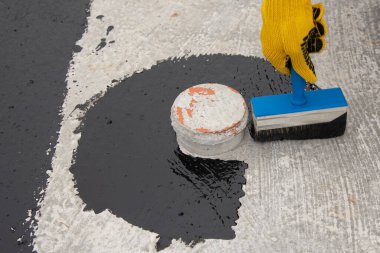İşçi temel üzerine bitumen mastic uygular