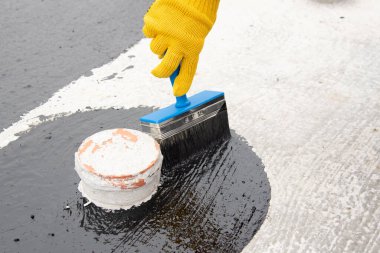 İşçi temel üzerine bitumen mastic uygular