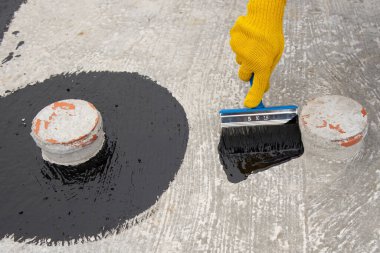 İşçi temel üzerine bitumen mastic uygular