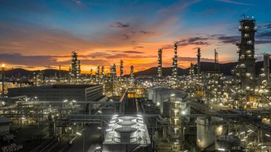 Alacakaranlıkta petrol depolama tankı ve petrokimya fabrikası endüstriyel arka planına sahip petrol rafinerisi, alacakaranlıkta hava manzaralı petrol ve gaz rafinerisi.