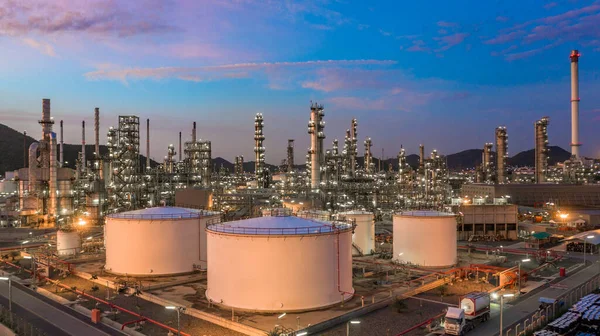 Alacakaranlıkta petrol depolama tankı ve petrokimya fabrikası endüstriyel arka planına sahip petrol rafinerisi, alacakaranlıkta hava manzaralı petrol ve gaz rafinerisi.