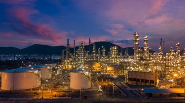 Alacakaranlıkta petrol depolama tankı ve petrokimya fabrikası endüstriyel arka planına sahip petrol rafinerisi, alacakaranlıkta hava manzaralı petrol ve gaz rafinerisi.