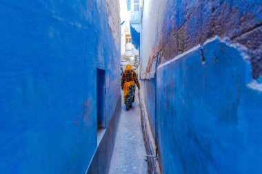 Hindistan 'ın geleneksel Hindistanlı kadınları Hintli Saree' yi giydirip mavi Jodhpur şehrinin dar mavi sokaklarında yürüyorlardı, Rajasthan, Hindistan.