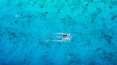 Mercan resifi üzerinde açık ve turkuaz su ile açık denizde hareket eden teknenin yukarıdan görünüşü, tropikal lagünü, Moalboal 'u, Oslob' u, Cebu Adası 'nı, Filipinler' i terk etti..