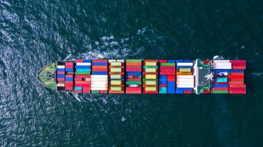 Ticari nakliye ve ihracat için konteynır taşıyan konteyner kargo gemisi ticari limana yanaşıyor..
