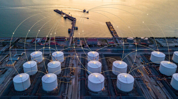 НПЗ с резервуаром для хранения нефти и нефтехимическим заводом на промышленном фоне в сумерках, НПЗ с воздушным обзором в сумерках
.