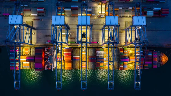 Container ship working at night, Business import export logistic and transportation of International by container ship in the open sea, Aerial view container ship loading and unloading at night.