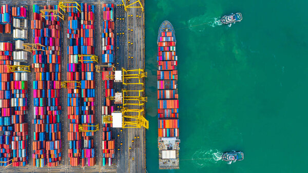Container ship working at industrial port, Business import and export logistic and transportation of International by container ship in the open sea, Aerial view container ship loading and unloading.